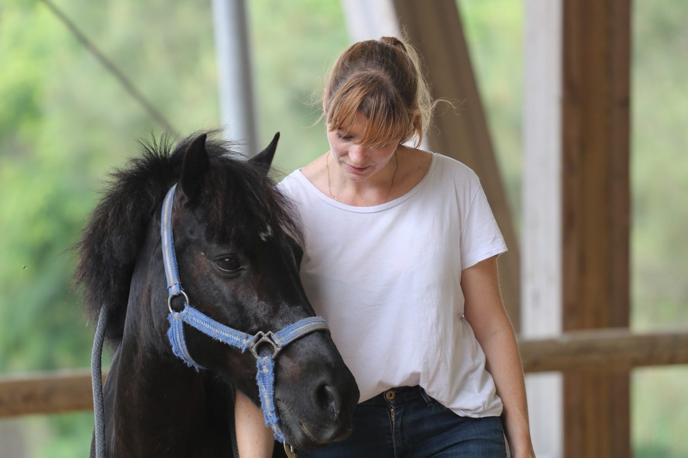 Une participante pose la main sur l'encolure d'un poney noir